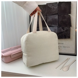 Detail of corduroy texture and top zipper closure on a beige large capacity lunch bag