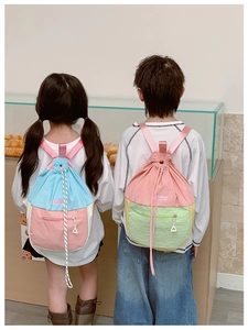 Détail du sac à dos enfant avec fermeture à cordon et poche zippée au dos du sac