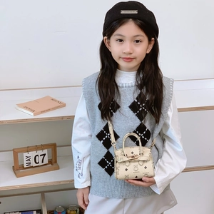 Kids beige shoulder bag with bear print and metal lock worn by child model with beret