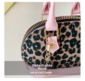 Detail of detachable gold hook and pink leopard print fabric on a mini girls bag