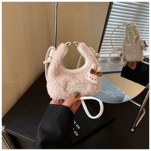 Close-up of pink fuzzy fleece kids mini crossbody bag with cute bunny pendant and embroidery