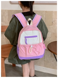 Rear view of pink and purple patchwork school bag on a child in a cozy indoor setting