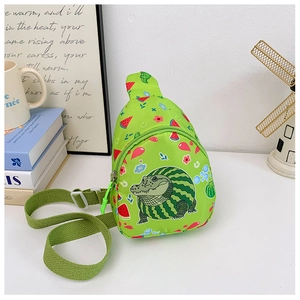 Détail du sac de poitrine vert pour enfants avec imprimé crocodile sur table blanche