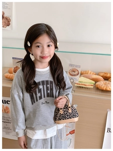 Mini leopard print crossbody bag with gold chain strap shown in a warm bakery scene