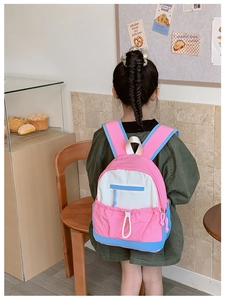 Back view of a child wearing the colorful large capacity school backpack in a cozy shop