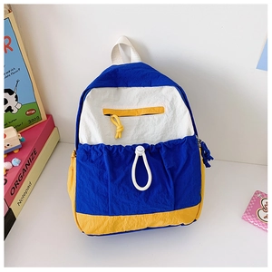 Detail showing the multi-color nylon backpack with front drawstring and yellow zipper pocket