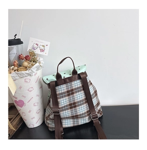 Detail of plaid fabric kid backpack with green star pattern flap and metal buckle