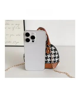 Dettaglio del confronto taglie tra la mini borsa pied de poule e uno smartphone