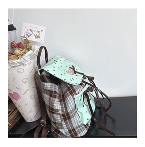Detail view of mint green plaid kids backpack with black star print and bow decoration