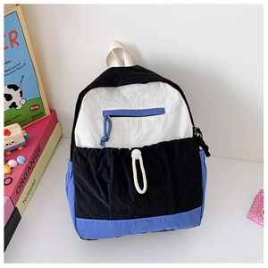 Detail of multi-color nylon school bag featuring blue zipper pocket and black drawstring