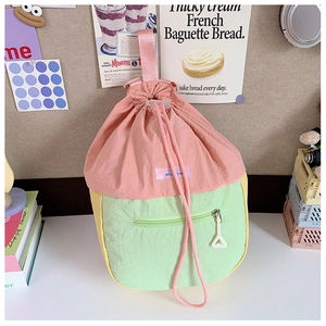 Détail du sac à dos à cordon tricolore avec poignées roses et poche zippée pratique