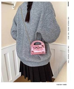 Sac à main rose brillant pour fille avec nœud, porté à l'épaule par le mannequin