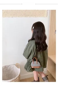 Dettaglio borsa bimbi pied-de-poule con bordo in pelle marrone e tracolla a catena