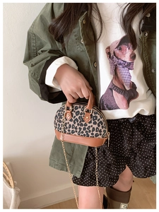 Close-up of leopard print toddler handbag with brown leather base and gold chain strap