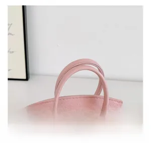 Détail de la texture grainée rose et des doubles poignées de ce sac à main enfant