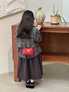 Detail of red quilted mini bag with gold chain strap and metallic lock for kids