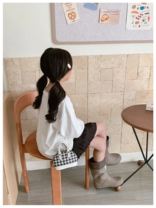 Mini borsa pied-de-poule classica abbinata a outfit autunnale da bambina con stivali