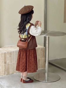 Close-up of a vintage brown leather crossbody bag paired with a retro autumn outfit