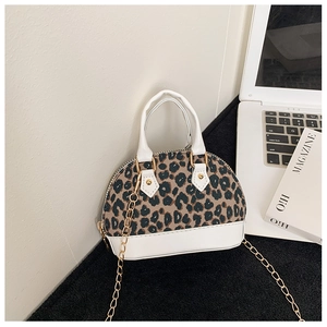 Detail view of mini leopard print shell bag with gold chain strap on desktop