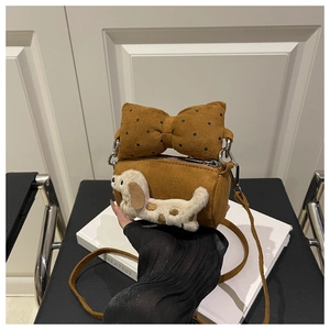 Detail einer braunen Plüschtasche mit gepunkteter Schleife und süßem Plüsch-Hunde-Dekor