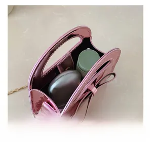 Détail du mini sac en cuir verni rose brillant montrant la capacité de rangement interne