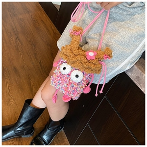 Détail du sac à bandoulière tricoté rose pour enfant avec fleurs et grands yeux