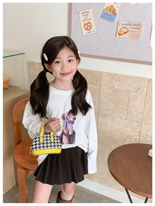 Dettaglio di una mini borsa a conchiglia pied de poule gialla per bambina autunnale