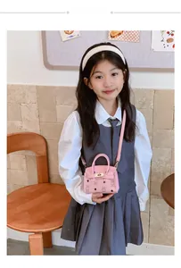 Détail du sac à main rose pour enfants avec ours, fermoir doré et bandoulière