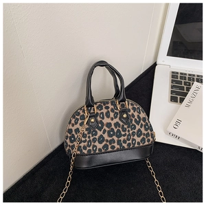 Mini leopard print shell bag with golden chain and black handles on a desk