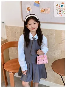 Sac à main rose pour enfant avec imprimé ours, porté avec robe plissée grise et cravate