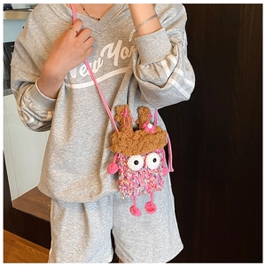 Sac monstre rose au crochet fait main avec de grands yeux porté par un mannequin