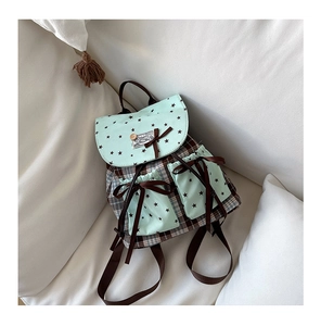 Detail of mint green school backpack with star patterns and brown ribbon bows
