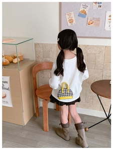 Dettaglio mini borsa a conchiglia pied-de-poule da bambina con manico giallo e catena