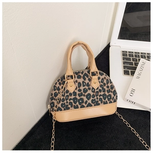Detail of leopard print shell bag featuring gold chain strap and beige faux leather trim