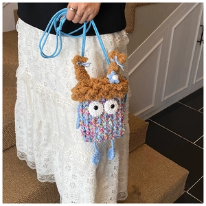 Détail du sac monstre crocheté main avec nœud bleu et finitions tricotées colorées
