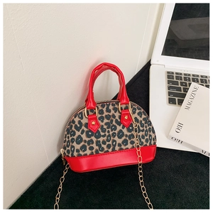 Close-up of leopard print mini shell bag with red leather base and gold chain strap