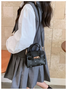 Détail du mini sac à bandoulière noir avec imprimé dessin animé et fermoir doré