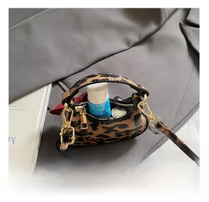 Vue intérieure montrant la capacité de rangement du mini sac bandoulière léopard
