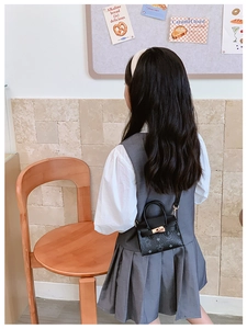 Détail d'un mini sac bandoulière imprimé avec boucle dorée et motif sur cuir