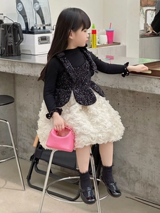 Detail of a white 3D floral textured skirt and a pink mini leather handbag for kids