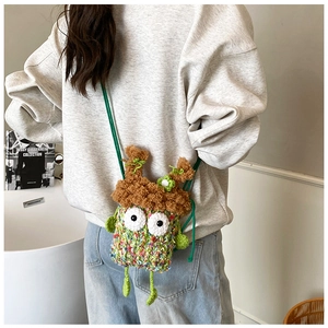 Détail d'un petit sac bandoulière monstre en crochet vert avec texture tricotée
