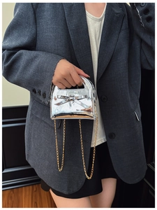 Détail du sac à main argenté en cuir verni pour fille avec nœud et chaîne dorée
