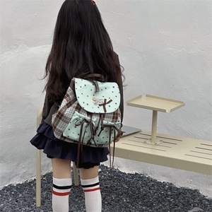 Mint green plaid kids backpack with bowknot and star pattern on outdoors background