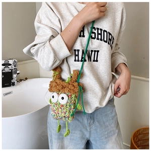 Détail du sac à bandoulière monstre vert tricoté main avec yeux de dessin animé et texture