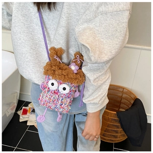 Détail du sac monstre crocheté main avec laine colorée, grands yeux et nœuds violets