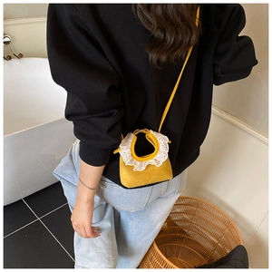 Détail du mini sac jaune avec bordure en dentelle blanche et texture en daim doux