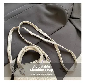 Detail show of white pebble leather mini handbag with adjustable strap and blue stitching
