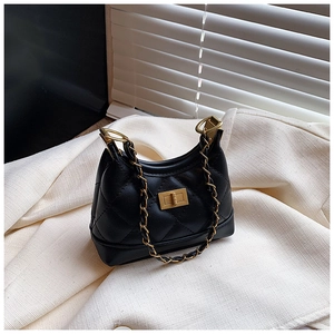 Detail of black quilted leather hobo bag with gold metal twist lock and chain strap
