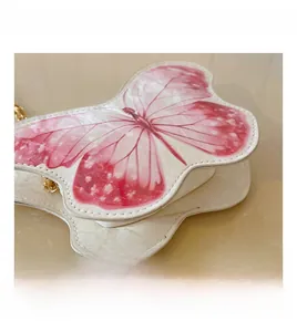 Detail of white butterfly purse for girls featuring pink print and golden chain strap
