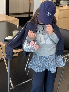 Détail d'un mini sac à main argenté matelassé avec nœud rose pour fille en situation réelle
